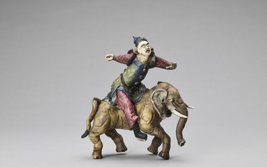A GLAZED TERRACOTTA FIGURE OF A DIGNITARY RIDING...