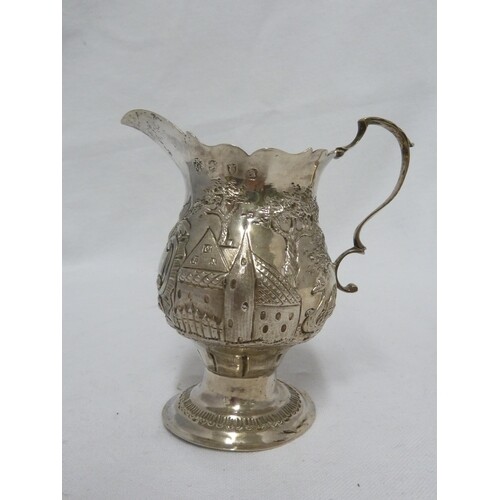 A George III silver cream jug of baluster form with leaf cap...