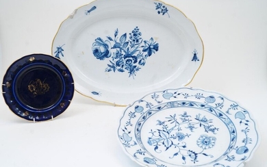 A Meissen porcelain ‘Zwiebelmuster’ blue and white serving plate, 20th century, blue underglaze and incised marks, with wire metal hanging apparatus, 33.5cm diameter; together with a Meissen oval platter, blue underglaze crossed swords mark, the...