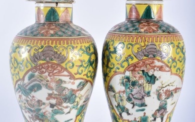 A PAIR OF 19TH CENTURY CHINESE FAMILLE JAUNE PORCELAIN VASES AND COVERS Qing, painted with figures i