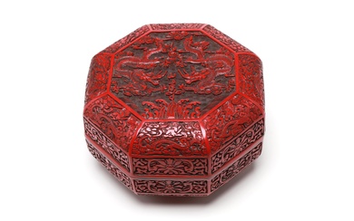 A cinnabar lacquer covered box decorated in relief with dragons among floral vine scrolls