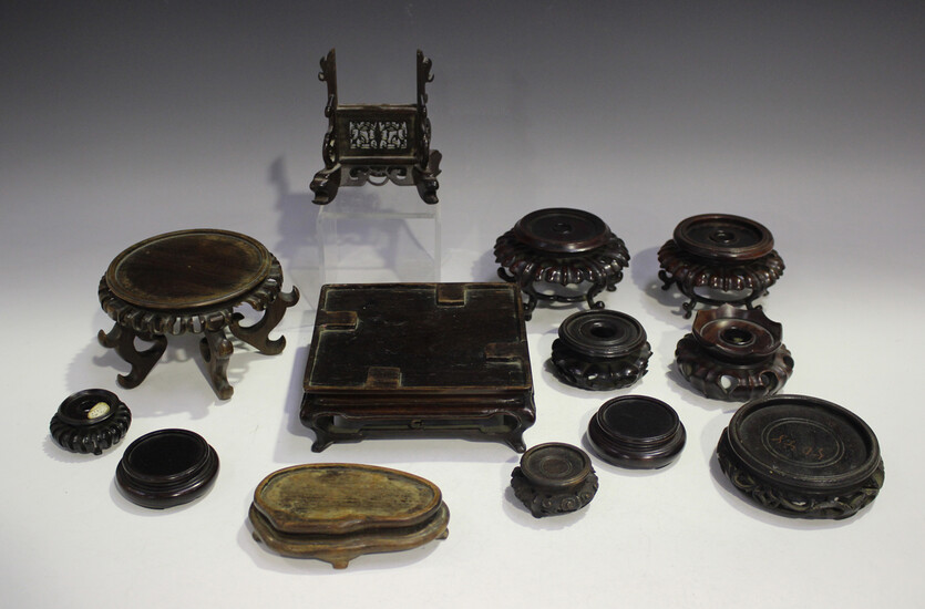A collection of thirteen Chinese wood stands, late 19th century or later, including a small circular