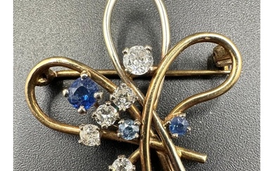 A diamond and sapphire spray brooch on yelllow and white gol...