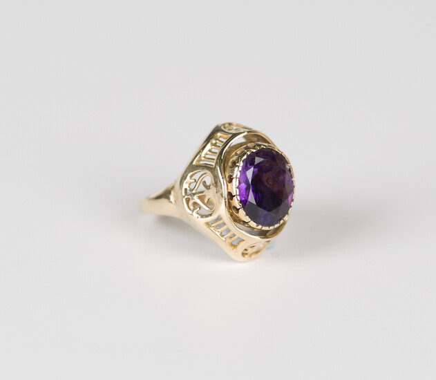 A gold, amethyst and coral ring, the rotating centre mounted with an oval cut amethyst to one side a
