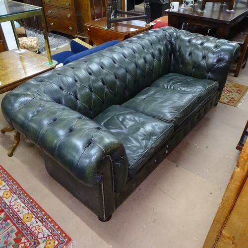 A green studded leather-upholstered Chesterfield settee, wit...