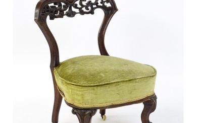 A mid / late 19thC mahogany nursing chair with a pierced, ca...