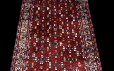 A modern red ground Persian style carpet with geometric design,...