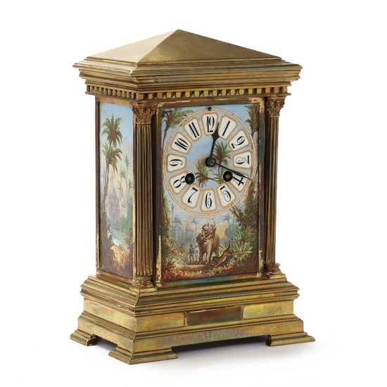 A striking mantel clock of bronze with porcelain plaques decorated in colours, the case in the shape of tempel. Late 19th century. H. 28 cm. W. 19 cm. D. 12 cm.
