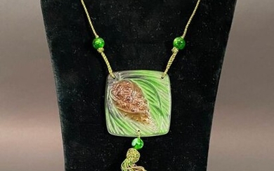 Argy Rousseau (French, 1885 ~ 1953) A pate-de-verre glass square shaped pendant decorated with a pine cone design on silk cord with tassels. Circa 1920 Pendant height 5.5 cm.