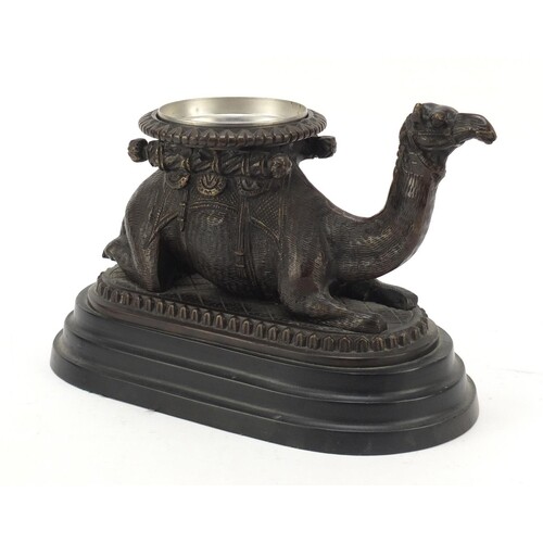 Bronze model of a crouching camel raised on oval stepped bas...