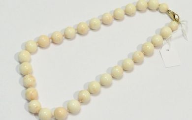 Collier de perles de corail blanc poli légèrement moucheté orange DE 13mm environ. Le fermoir en or jaune. Poids brut : 108g. Long : 49 cm.