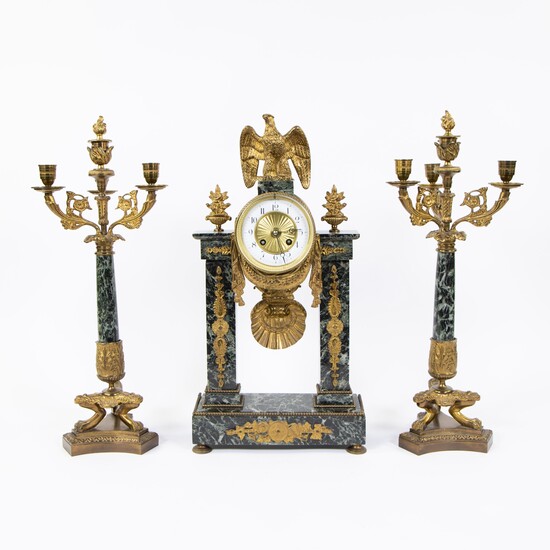 French green veined marble column clock decorated with eagle and 2 candlesticks with 4 light points, 19th C.