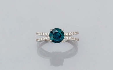 Ring in white gold, 750 MM, set with a green sapphire with changing colour, weighing about 1.90 carat between two long lines of brilliants, size: 53, weight: 3.6gr. gross.