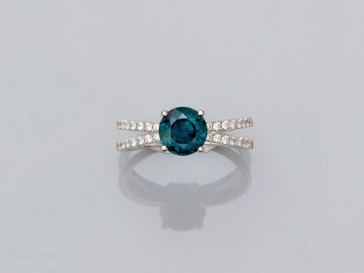 Ring in white gold, 750 MM, set with a green sapphire with changing colour, weighing about 1.90 carat between two long lines of brilliants, size: 53, weight: 3.6gr. gross.