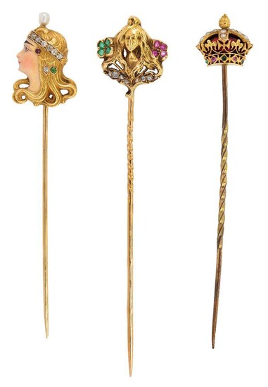 Three gold, diamond, gem-set and enamel stickpins, one designed as the profile of an Art Nouveau maiden decorated with emeralds, rubies and diamonds, French marks, one designed as the profile of an Art Nouveau maiden with enamel face, and diamond...
