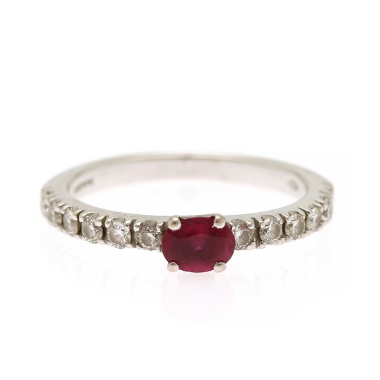 Wempe: A ruby and diamond ring set with an oval-cut ruby flanked by numerous brilliant-cut diamonds, mounted in 18k white gold. Size 53.