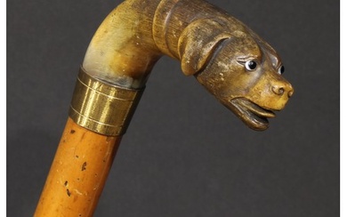 A 19th century novelty walking stick, the horn handle carved...