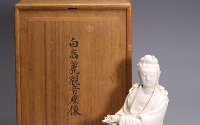 A BLANC DE CHINE SEATED GUANYIN FIGURE WITH ZITAN STAND