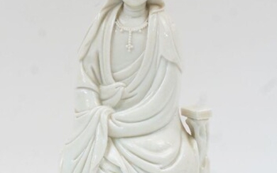 A Chinese blanc de chine figure of Guanyin, late Republic period, on hardwood base, figure 24.5cm high, total 27.5cm high