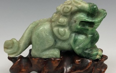 A Chinese carved green carnelian figure of a crouching Buddh...