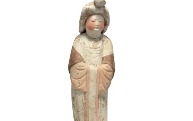 A Chinese pottery figure of a court lady, Tang dynasty Modelled standing...