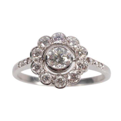 A DIAMOND DAISY CLUSTER RING c.0.80ct total weight, on a pl...