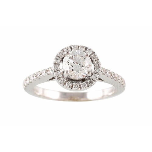 A DIAMOND HALO CLUSTER RING, with diamond shoulders, mounted...