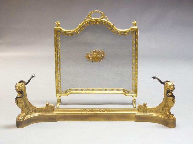 A French gilt-bronze adjustable fender, late 19th century, in the manner of Barbedienne, the chenets modelled as tiger monopodiae with serpents in their mouths, 36cm high; together with a French gilt-bronze fire-screen, 20th century, the wire-mesh...