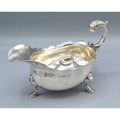 A George II Silver Sauce Jug with shaped scroll handle and t...