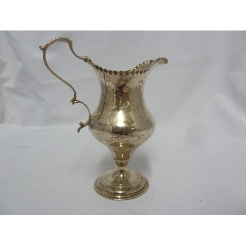 A George III silver cream jug of plain baluster shape with a...