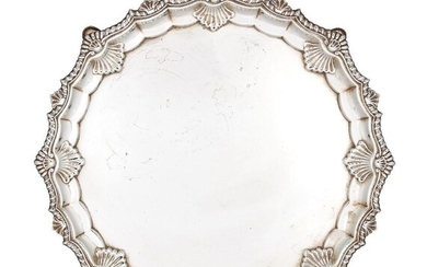 A George V silver salver, London, c.1911, Searle & Co., of shaped, circular form with shell and gadroon edge to four pad feet, 32cm dia., approx. weight 28.6oz