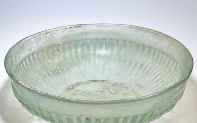 A LIGHT GREEN GLASS RIBBED BOWL.
