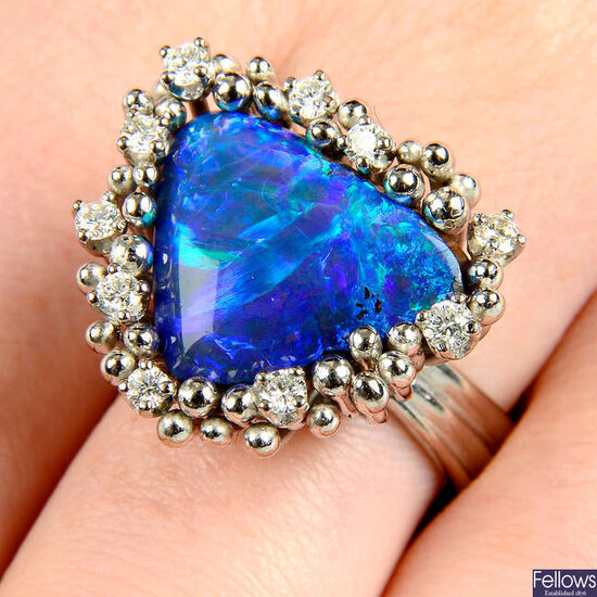 A boulder opal ring, with brilliant-cut diamond and bead surround, by Grima.