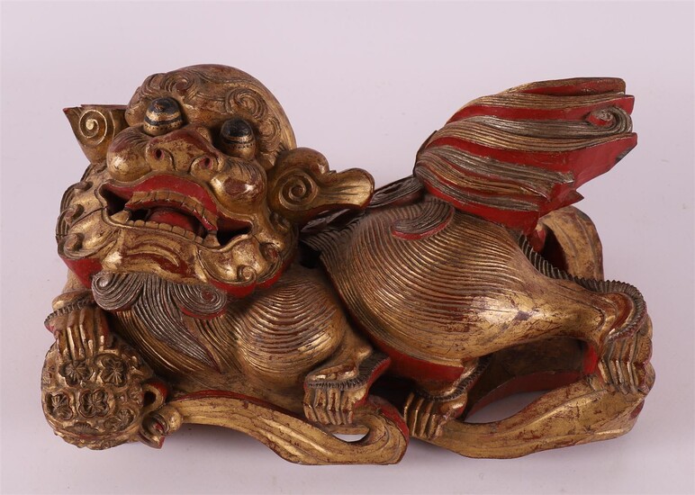 (-), A carved giltwood temple lion with flaming...