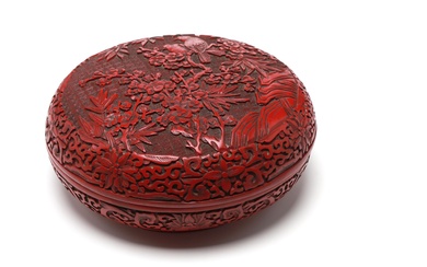 A cinnabar lacquer covered box decorated in relief with birds in flight among flowers