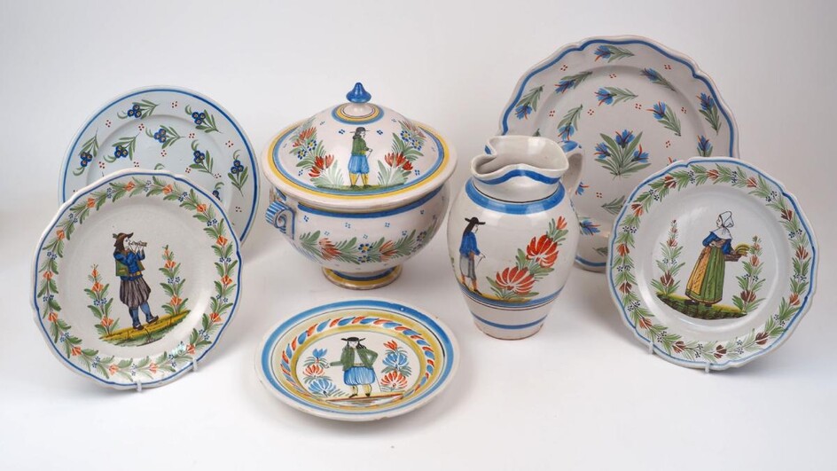 A group of French faience, late 19th/early 20th century, to include a pair of Quimper plates decorated to the centre with a musician and a maid each between sprouting plants, with a garland of flowers to the rim, the plates 24.4cm diameter...