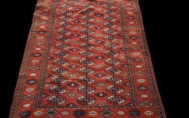 A modern red ground Persian style carpet with geometric design,...