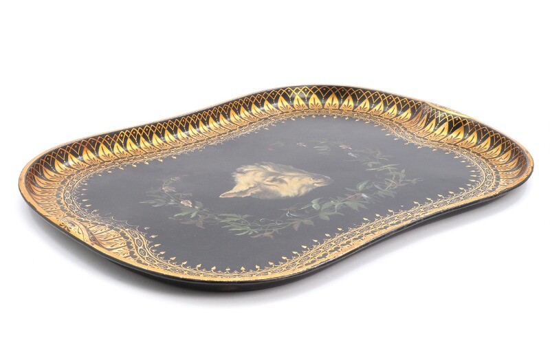 A painted and gilded metal tray, decorated with a rams head, flowers and foliage. Mid 19th century. L. 77. W. 57 cm.