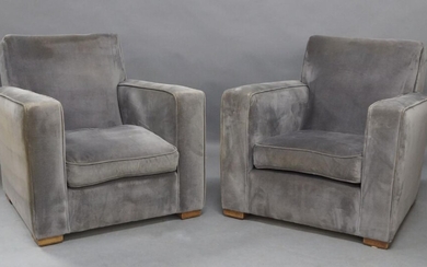 A pair of French Art Deco lounge chairs in the manner of Jacques Adnet, c.1940/50, with grey velvet upholstery, each having one loose seat cushion, raised on wooden block feet, each 78cm high, 76cm wide (2)