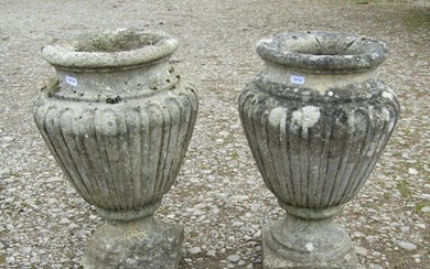 A pair of fluted weathered cast composition stone oviform ur...
