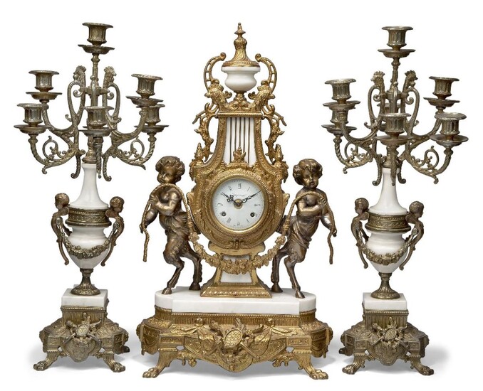 A white marble and gilt metal three piece clock garniture, early 20th Century, the clock case modelled as a lyre with cockerel head and acorn finials flanked to either side by a faun, surmounted by a marble campana urn, the enamel dial with Roman...