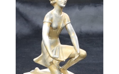 An Art Deco spelter figure of a kneeling young lady on onyx ...