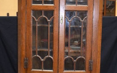 An Oak glazed door corner cabinet on a a stand with one central drawer and 2 front opening small sid