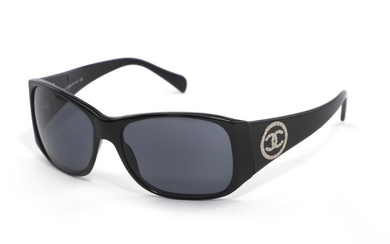 Chanel A pair of black sunglasses with golden logo embellished with imitated...