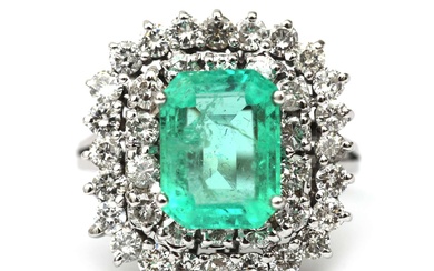 Een 14 krt. witgouden entourage ring met smaragd en diamant