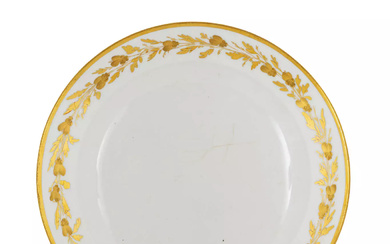 Plat rond en porcelaine à décor en or bruni d’une frise de feuillages.