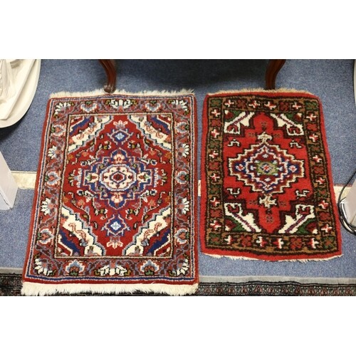 TWO SMALL WOOL RUGS each with a wine ground with central ser...