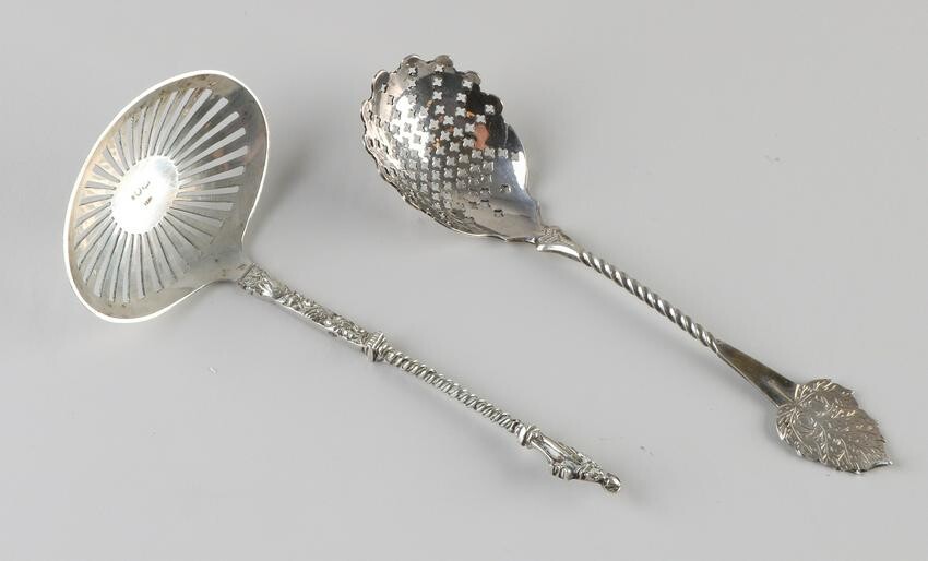 Two silver scattering spoons, 833/000, a scattering