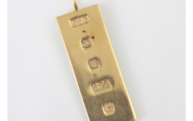 A 9ct yellow gold ingot pendant, the rectangular ingot stamp...