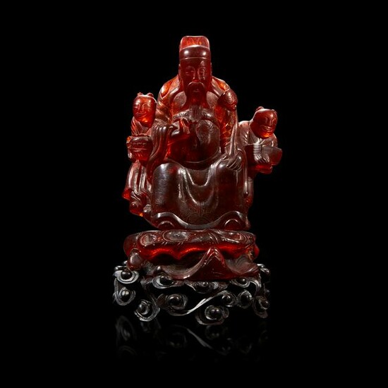 A Chinese carved amber figure of a sage and acolytes